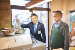 市長が焙煎機にコーヒー豆を投入する様子