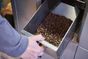 焙煎機から焙煎されたコーヒー豆を取り出す様子
