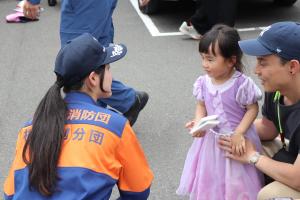 子どもたちに消防団広報グッズを渡している